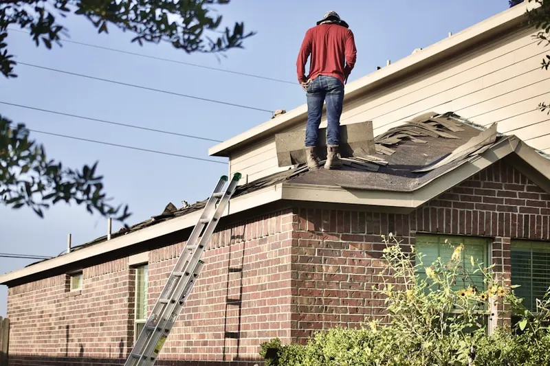 Professional roofer working on a residential roof in Denison